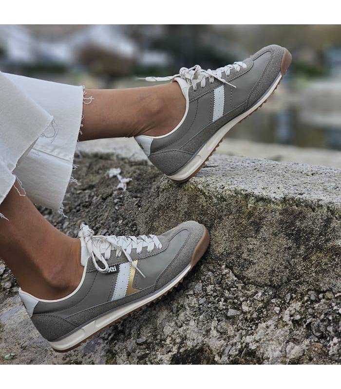 mujer posando con las zapatillas kaki de Xti puestas