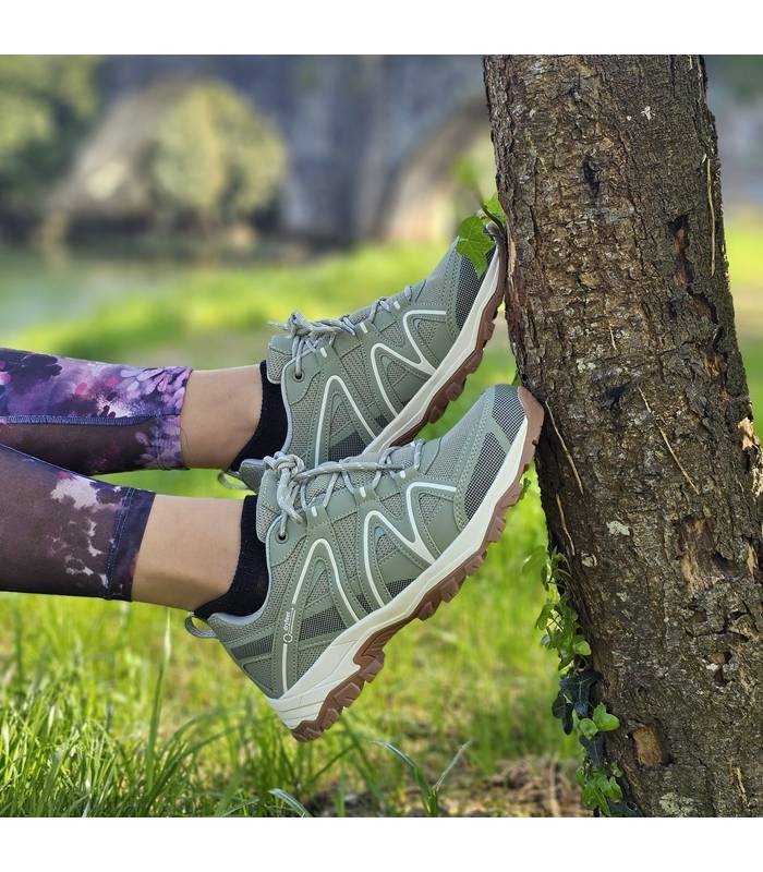 mujer posando junto a un arbol con las zapatilla impermeables de senderismo de elementerr puestas