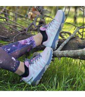 mujer en la pardera posando con las zapatillas de senderismo de jhyber puestas