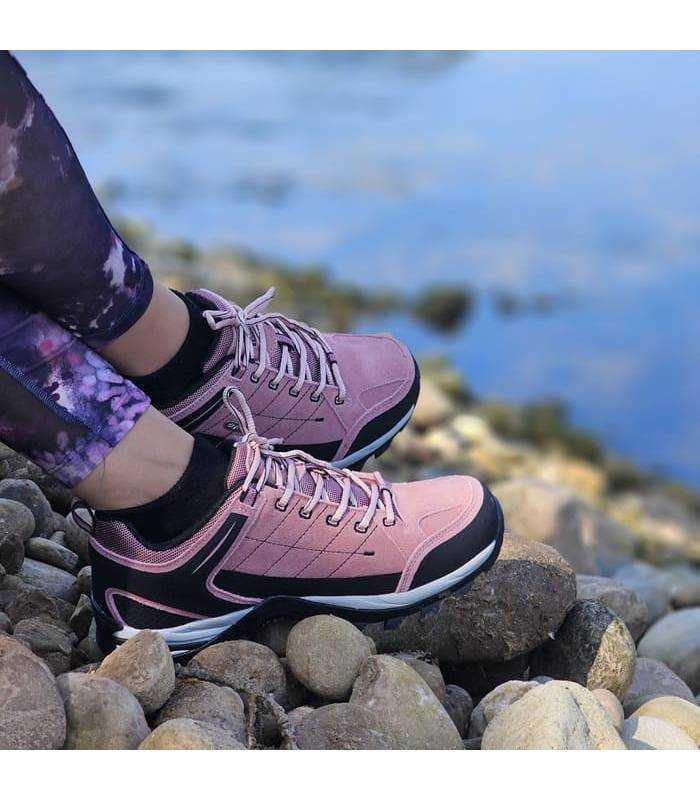 mujer posando con las zapatillas de senderimo impermerables de Elementerre puestas junto al rio