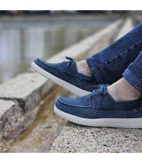 hombre pòsand con vaqueros con los nauticos ligeros azules de lona de rebajas