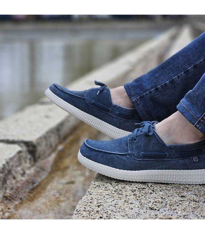 hombre pòsand con vaqueros con los nauticos ligeros azules de lona de rebajas