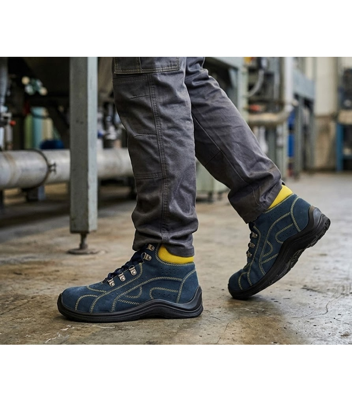 Botas Orion seguridad gamuza azul de Safety Jogger ouestas en un trabajador en una fabrica