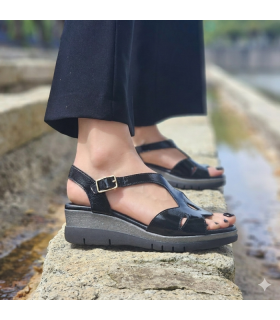 mujer posando juto al lago con las sandalias negras de Dchicas