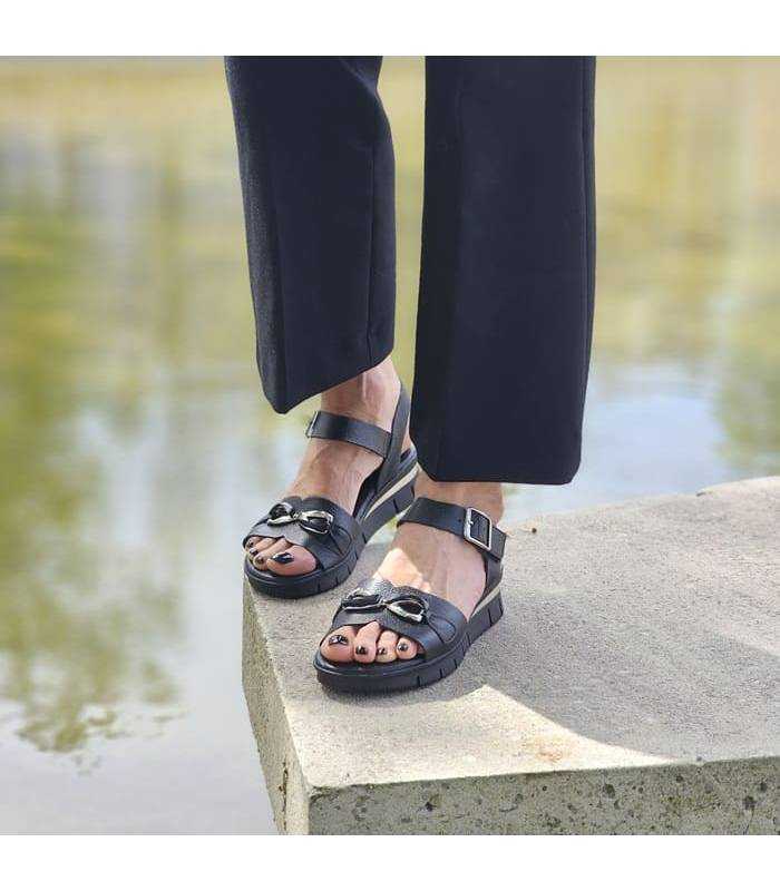 mujer posando con pantalon egro con las sandalias de piel negras de Valerias puestas