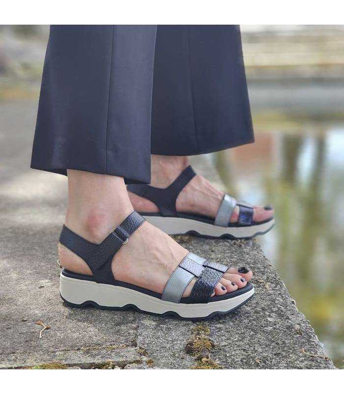 mujer posando junto al lago con las sandalias comodas de Leyland puestas