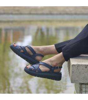 mujer posando junto al estanque con las sandalias anchas mujer de Cutillas puestas