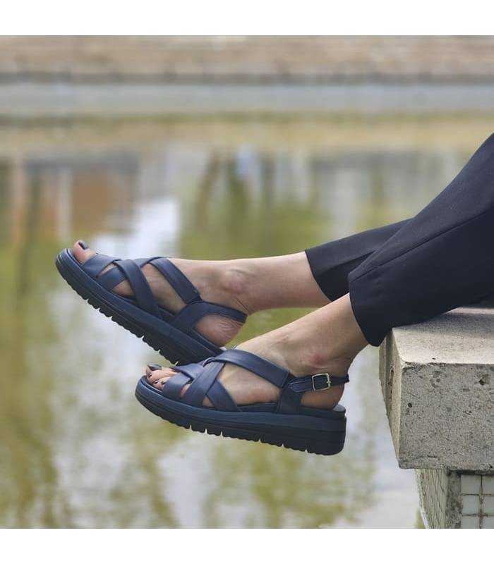 mujer posando junto al estanque con las sandalias anchas mujer de Cutillas puestas