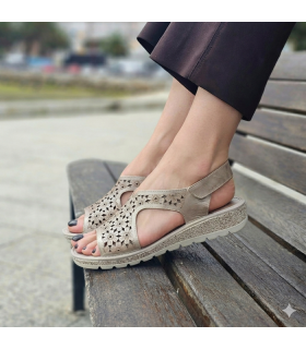 mujer posando en un banco con las sandalias de horma ancha comodas puestas