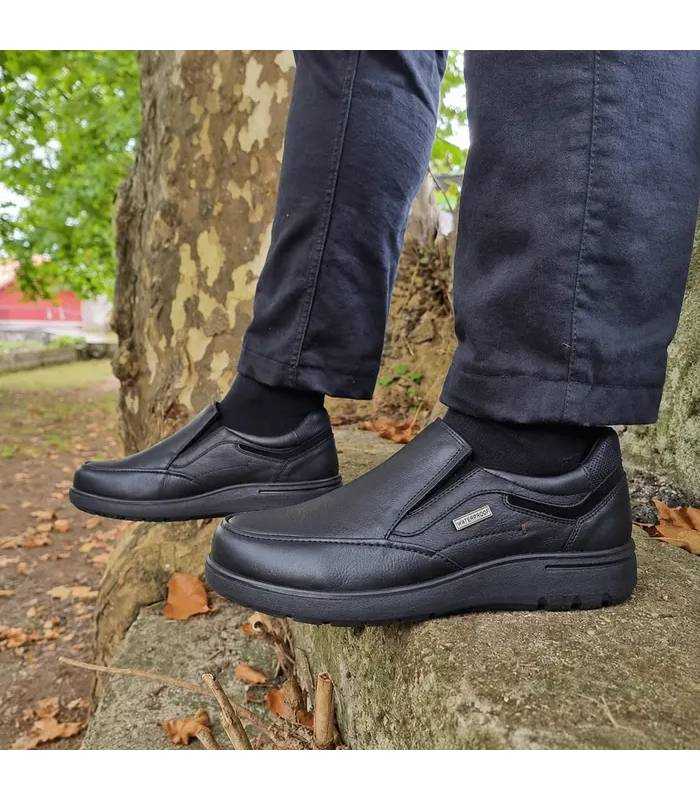 Zapatos mocasínes impermeables de piel negrtos comdos  de Luisetti puestos con pantalon negro