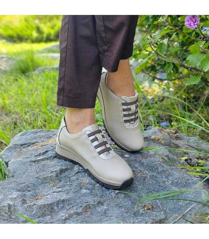 Zapatos mujer sin cordones beige puestos con pantalon marron